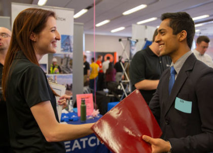 A recruiter and student shake hands at Career Fair