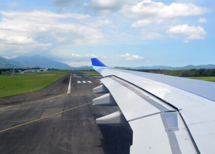 A photo of a plane wing over a runway.