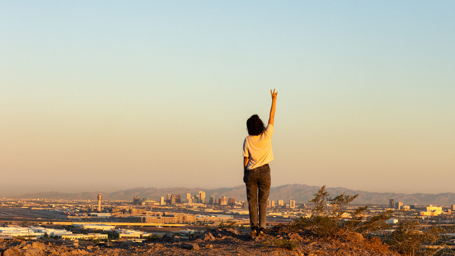 A person raising a Pitchfork hand sign on a mountain